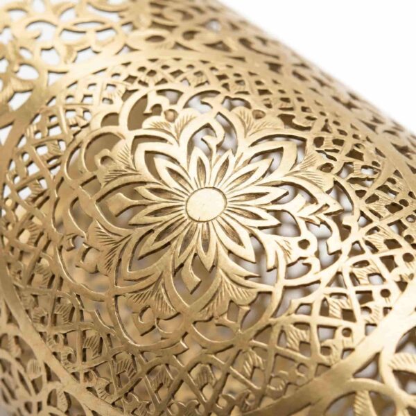 Close-up of hand-engraved brass filigree detail on Moroccan wall lamp showing star medallion Close-up of hand-engraved brass filigree detail on Moroccan wall lamp showing star medallion