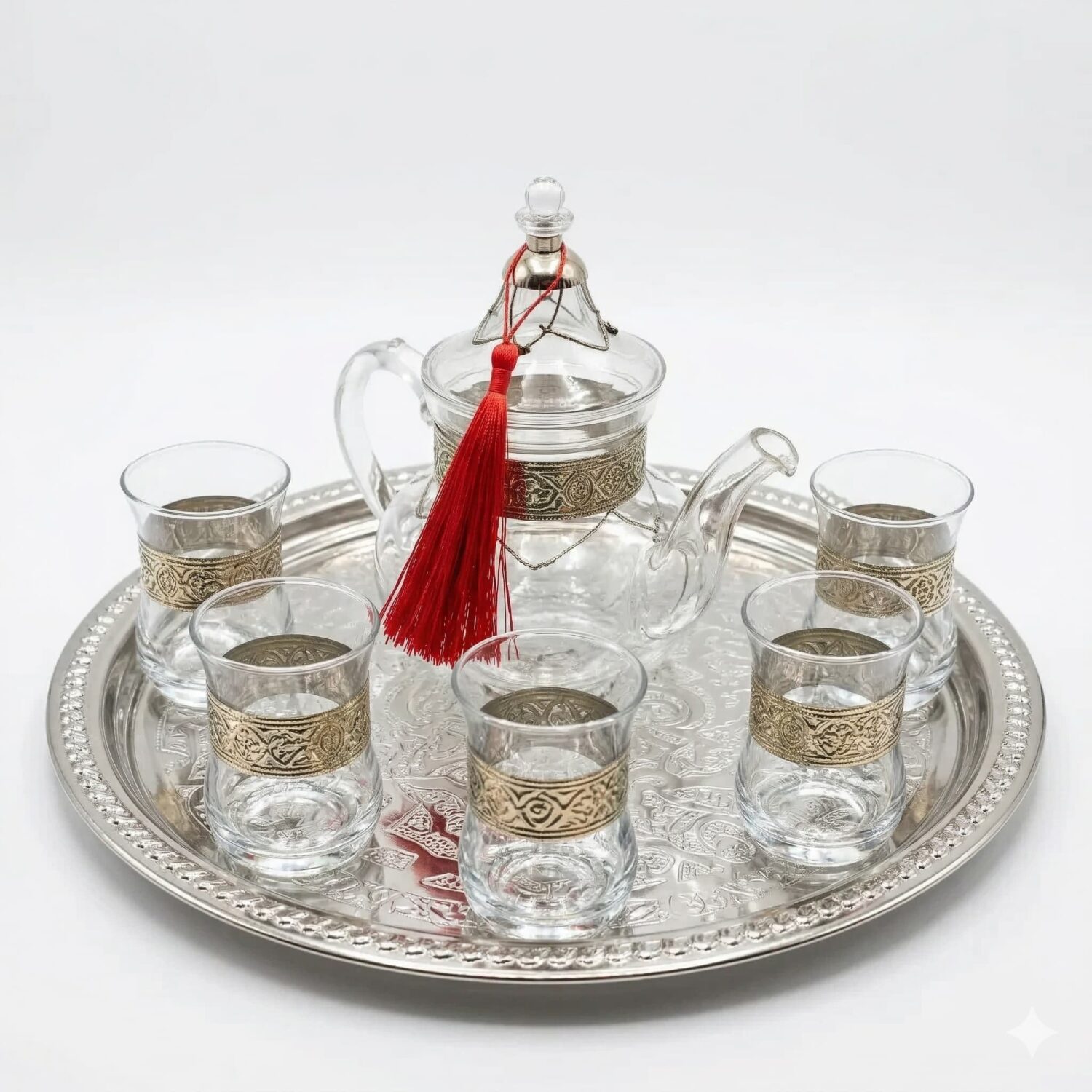 Silver engraved glass tea set with filigree teapot, six glasses, and round tray on white background Silver engraved glass tea set with filigree teapot, six glasses, and round tray on white background
