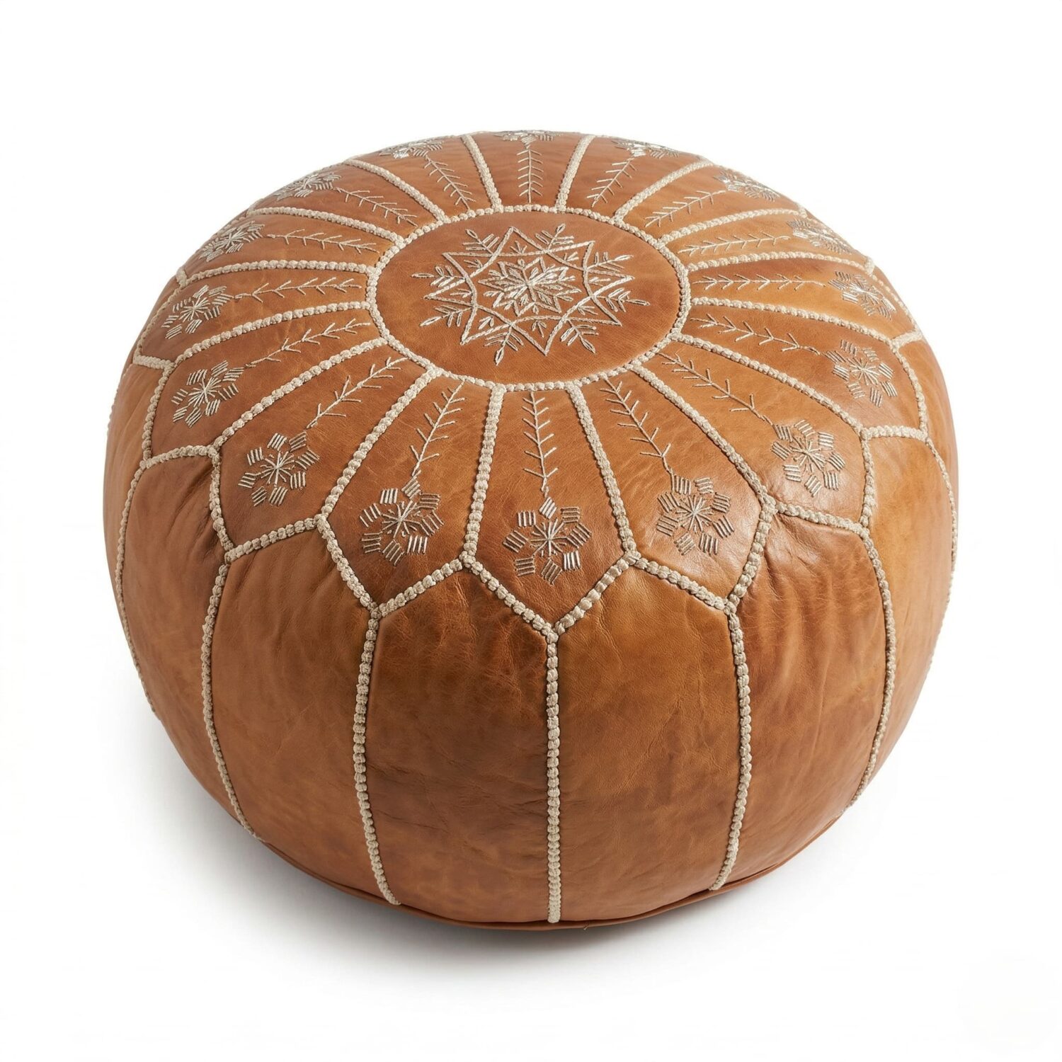 Embroidered leather round pouf in tan featuring geometric hand-stitched patterns, shown against a white studio background