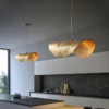 Two hammered brass leaf pendant lights glowing above a modern dark kitchen island