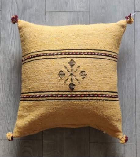 Handwoven Moroccan kilim pillow cover in mustard yellow with Berber motif and pompom corners