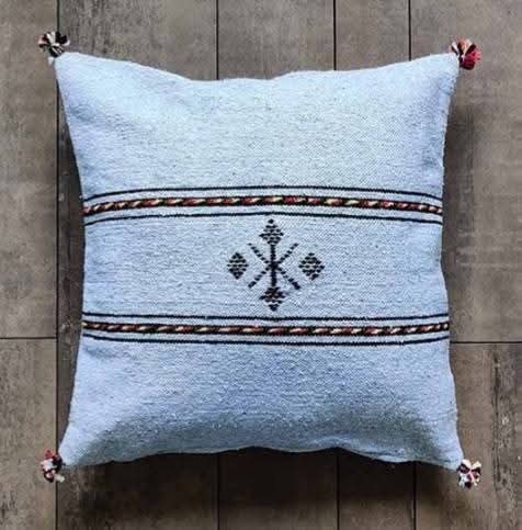 Handwoven Moroccan kilim pillow cover in sky blue with Berber motif and pompom corners