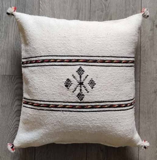 Handwoven Moroccan kilim pillow cover in ivory with Berber motif and pompom corners