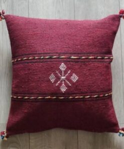 Handwoven Moroccan kilim pillow cover in burgundy with Berber motif and pompom corners