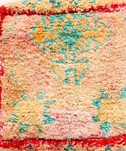 One-of-a-kind vintage Moroccan shag rug floor pouf in blush pink and cream with turquoise motifs and a red border