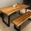 Live-edge walnut dining table with black steel legs and matching bench