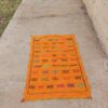 Saffron orange handwoven Moroccan kilim rug with rows of colourful Berber motifs
