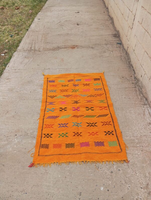 Saffron orange handwoven Moroccan kilim rug with rows of colourful Berber motifs