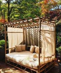 Eucalyptus canopy bed with cream cushions and curtains on a wooden deck