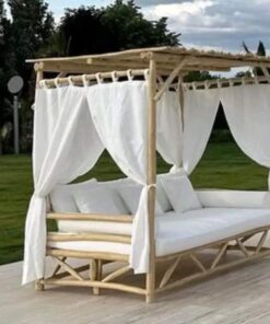 Moroccan eucalyptus canopy daybed with white curtains and outdoor cushions in a garden