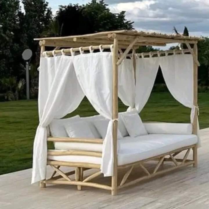 Moroccan eucalyptus canopy daybed with white curtains and outdoor cushions in a garden