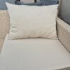 Sand beige water-resistant outdoor cushion on a rattan garden armchair