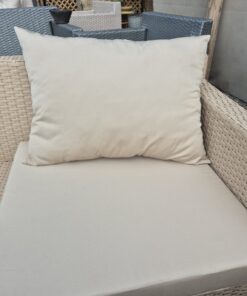 Sand beige water-resistant outdoor cushion on a rattan garden armchair