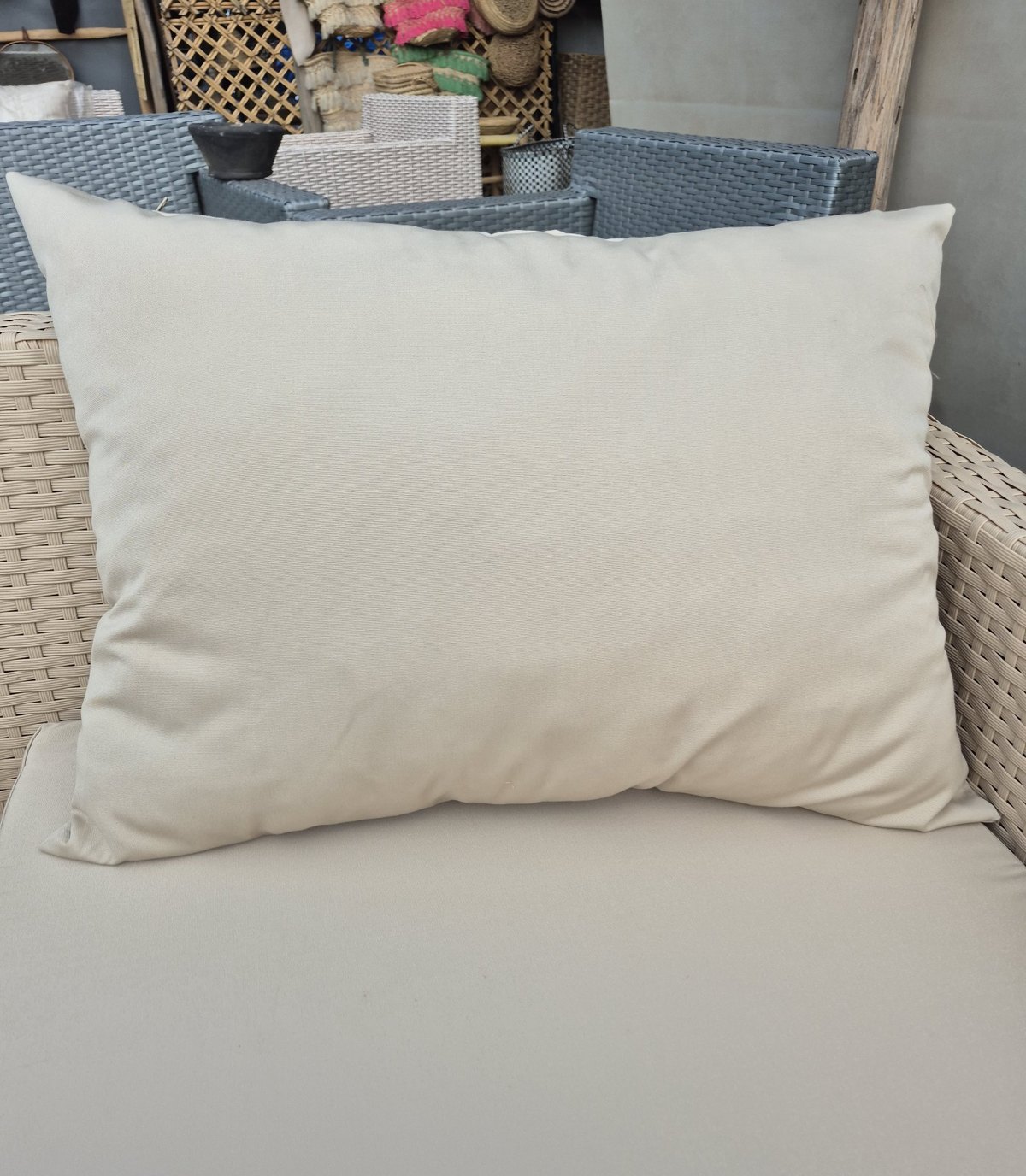 Large beige outdoor cushion on a wooden bench in the Marrakech workshop