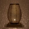 Moroccan brass pebble table lamp glowing and scattering dotted light across the walls