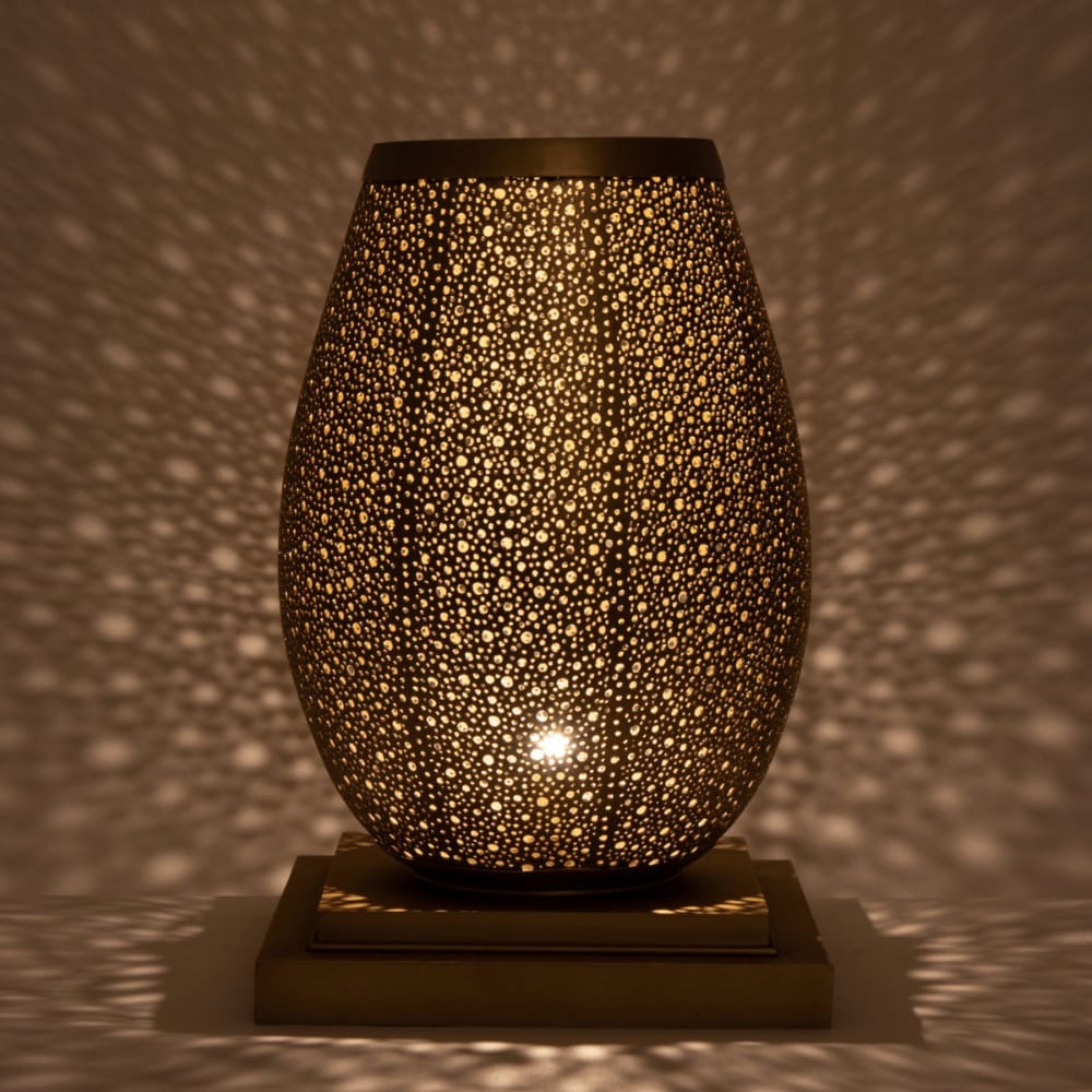 Moroccan brass pebble table lamp glowing and scattering dotted light across the walls