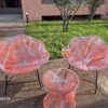 Pair of orange Moroccan flower-shaped rope lounge chairs with a matching rope side table in a Marrakech garden