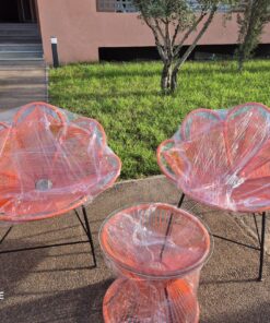 Pair of orange Moroccan flower-shaped rope lounge chairs with a matching rope side table in a Marrakech garden