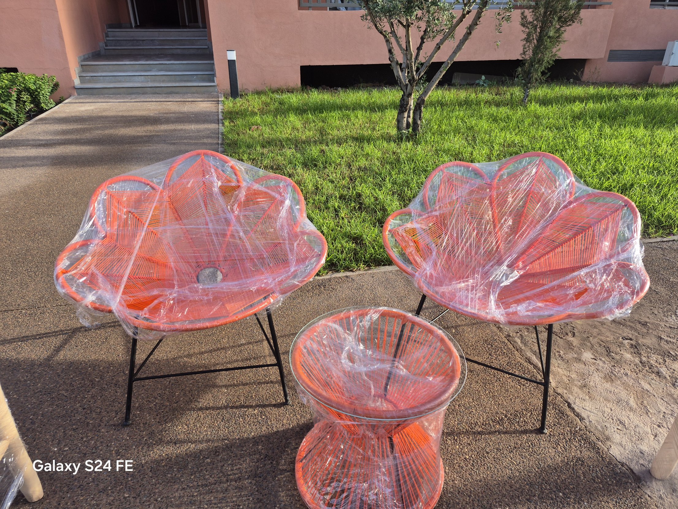 Orange petal-back rope chairs and glass-top rope side table, freshly made in the Marrakech workshop