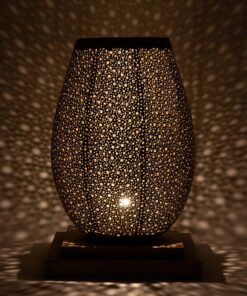 Hand-pierced brass table lamp casting a starry pattern of light in a dark room