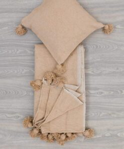 Folded sand beige pom pom throw with a matching cushion cover